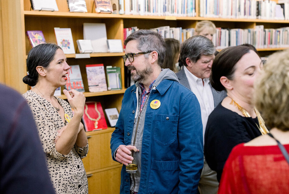 Guests mingle and speak to each other in a library