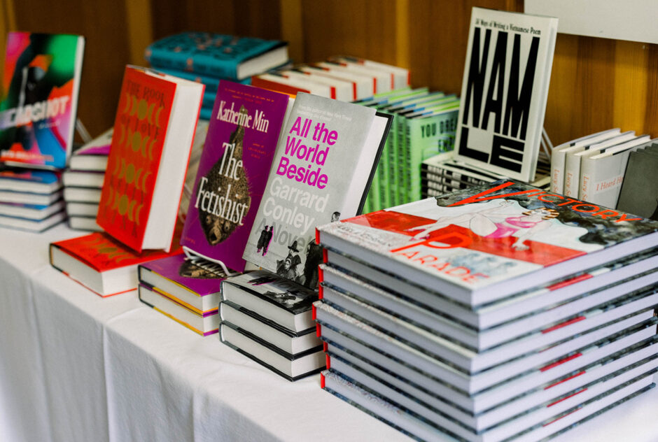 A colorful stack of books sits on a table with a white table cloth