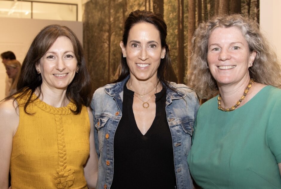 Three female-identifying people (Elizabeth Cafferty (left) and guests of MacDowell Presents) pose for a portrait, smiling at the camera.