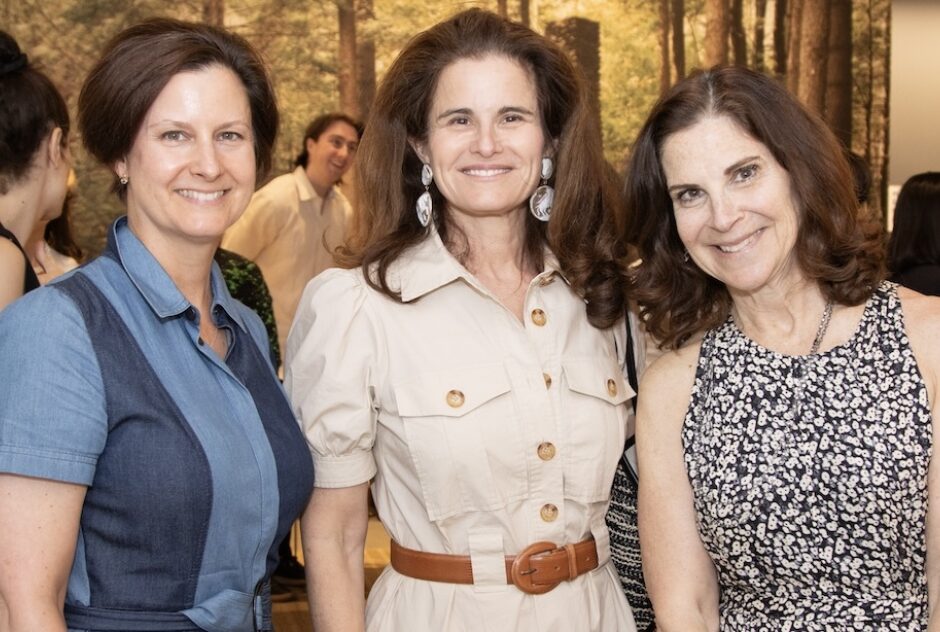 Three female-identifying people (Tania Carnegie [left], Merrill Mahan [center], and Anne Stark Locher [right]) pose for a portrait, smiling at the camera.