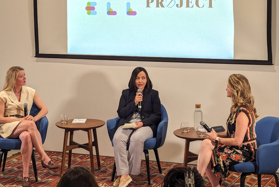 Three female-identifying people (Jane Ferguson, Zahra Nader, and Xanthe Scharff) sit in chairs and hold mics before an audience.