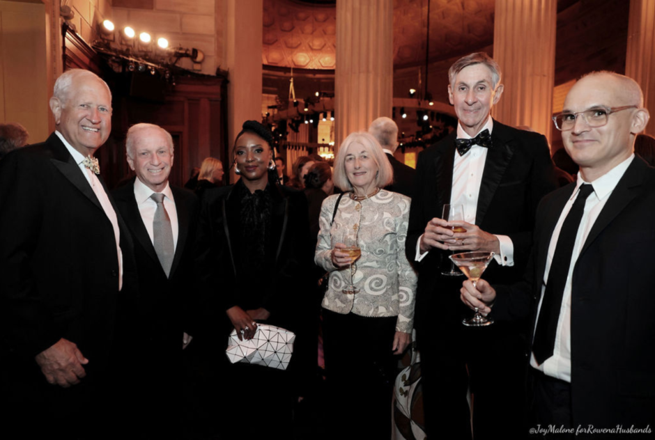 A group of guests stand and pose for a photo at a cocktail hour