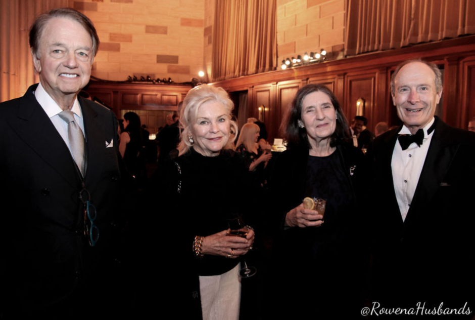 A group of older people in formal wear smile for a photo at a formal event