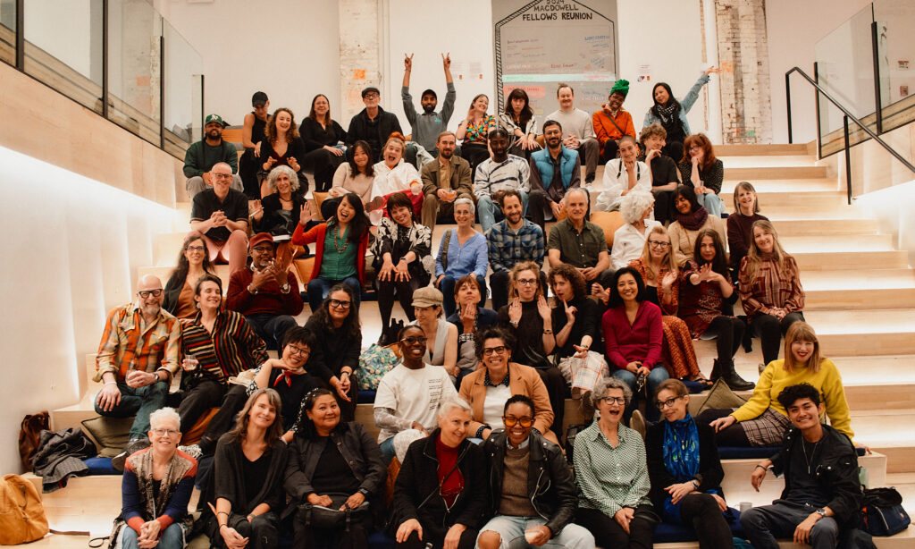 Fellows pose for a celebratory group photo on a staircase