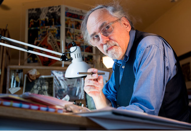 Portrait of Art Spiegelman working at his desk.