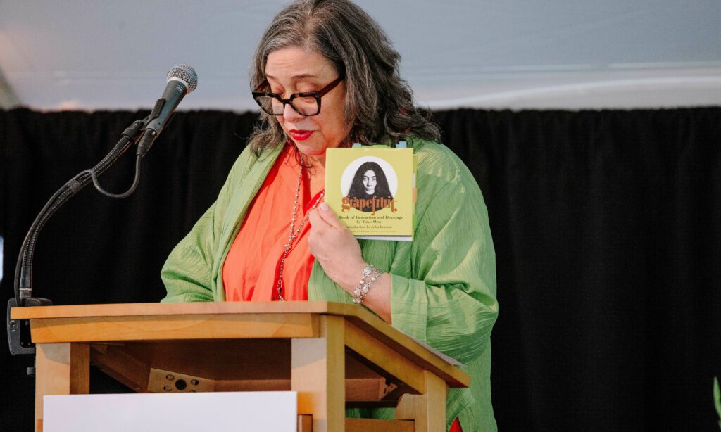 Nora Halpern displays Yoko Ono's Grapefruit as she delivers introductory remarks about the 2024 Edward MacDowell Medalist.