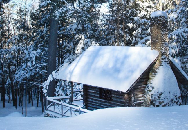 Log Cabin in winter surrounded by snow