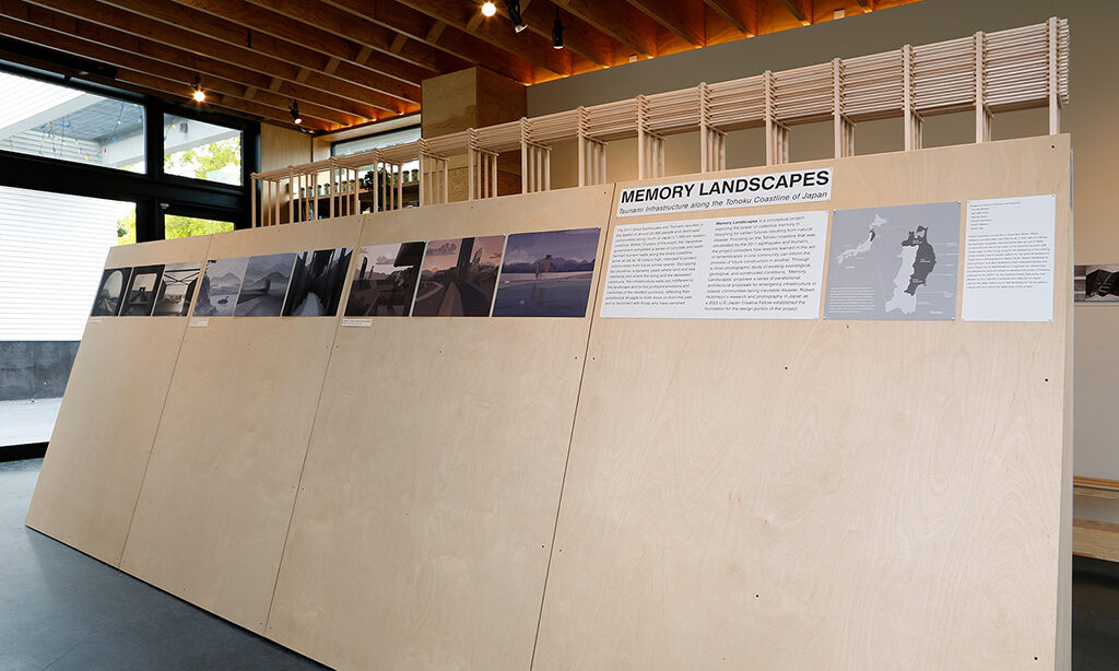 A wooden a-frame structure displaying architectural renderings and models.