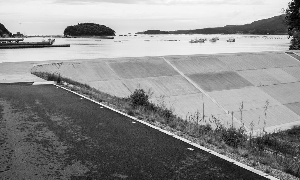 A black and white photo of a earth and concrete berm.