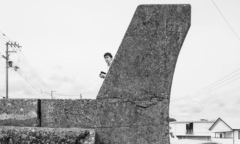 A black and white photo of the cross section of a curving concrete wall.